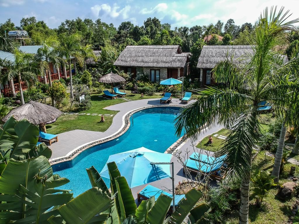 Hồ bơi thiết kế độc đáo và sáng tạo. Xung quanh trồng nhiều cây xanh tạo điểm nhấn tại Cottage Village